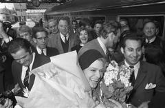 Arrival of Melina Mercouri at Amsterdam Central Station wearing beret and holding Greek flag