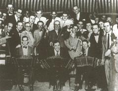 Carlos Gardel with bandoneon flanked by jockeys Irineo Leguisamo and Alfredo Peluffo at farewell party in Buenos Aires 1933