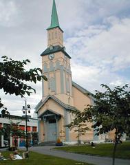 Tromsø Cathedral in Norway during winter with snow-covered ground and overcast sky