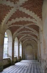 Mediterranean cloister garden with stone arches and tall trees