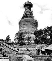 Traditional Chinese pagoda with multiple tiers and ornate roof details surrounded by greenery