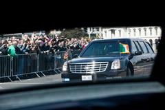 Motorcade of President Barack Obama and First Lady Michelle Obama making a left turn from Matt Talbot Bridge onto City Quay in Dublin, Ireland with the Custom House in the background