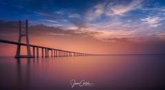 Sunrise over Vasco da Gama Bridge in Lisbon with river Tejo and cityscape