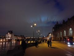 View from Musée d'Orsay to Louvre with vibrant light show at night