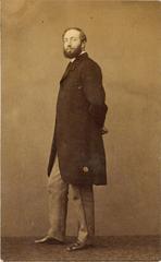 Portrait photograph of caricaturist Louis Morel-Retz standing, body turned three-quarters, looking at the camera