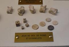 Vintage bone dice, pawns, and knucklebones on display at Musée Saint Rémi in Reims