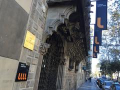 Entrance of Institut Ramon Llull building with ornate stone facade and wrought iron sign