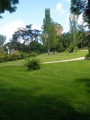 Scenic view of Parque del Oeste with lush greenery, walking paths, and trees in Madrid