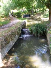 Scenic view of Parque del Oeste in Madrid with a pond, green trees and a clear blue sky