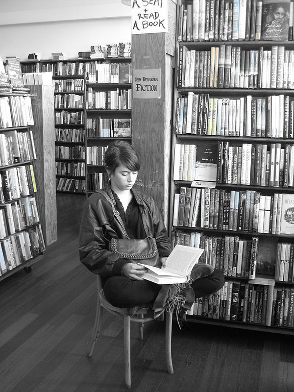 USF student Christie Hayden reading inside City Lights Bookstore