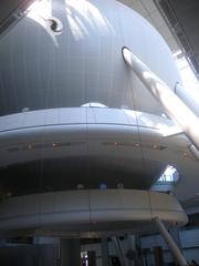 Modern architectural structure viewed from bottom lobby looking west with glass walls and metal framework