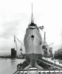 Forward view of USS Bronstein (FF-1037) frigate showing sharp clipper bow and large sonar dome on launching ways at Avondale Shipyards, 1962