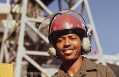 Avondale shipyard worker wearing special ear muffs for industrial noise protection