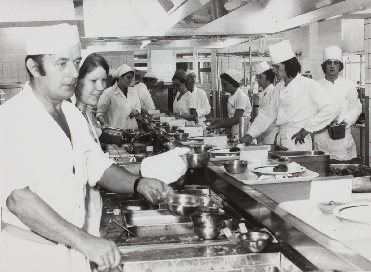 Black and white photo of meal preparation in the kitchen of Academisch Ziekenhuis Leiden in 1975