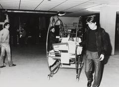 Black and white photo of patient transfer on shock-absorbing stretcher from old to new building at Academisch Ziekenhuis Leiden, 1985
