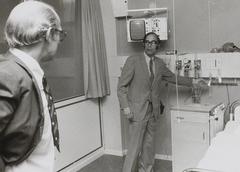 Black and white photo of Professor Dr. Arntzenius at the cardiac monitoring center in the Academic Hospital Leiden, with medical monitoring equipment and hospital beds