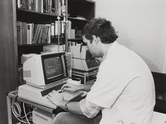 Black and white photo of a person operating the keyboard of a narcose-computer at Academisch Ziekenhuis Leiden in 1984