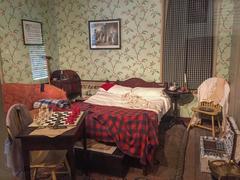 Bedroom area with bed, tables, chairs, and personal items at Thaddeus Kosciuszko National Memorial in Pennsylvania