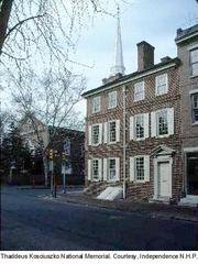 The old cracked Liberty Bell at Independence National Historical Park with Independence Hall in the background