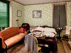 Bedroom with orange upholstered sofa along left wall and bed in center of room at Thaddeus Kosciuszko National Memorial