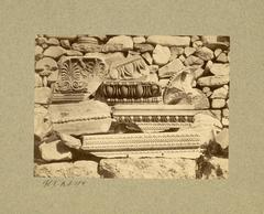 Fragments of sculpted blocks from the Erechtheion showcasing detailed architectural elements like anthemion, oves, heart-shaped rays, pearls, twists, braids, meanders, and rosette with a small bird between palmette and lotus flower
