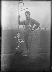 Portrait of Paul Cans conducting experiments on the Eiffel Tower with a device called 'ouistiti' for climbing ropes