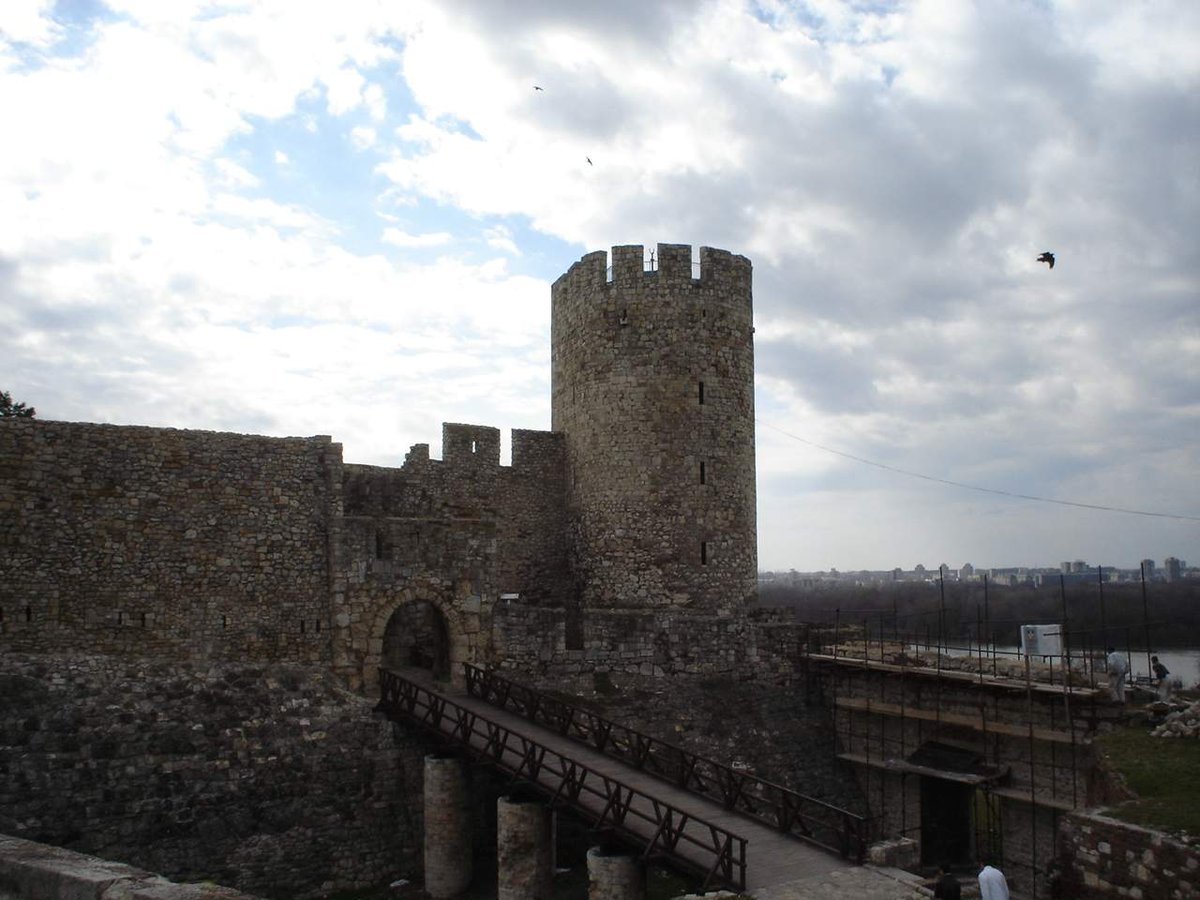 Ancient stone fortress walls with battlements under a cloudy sky