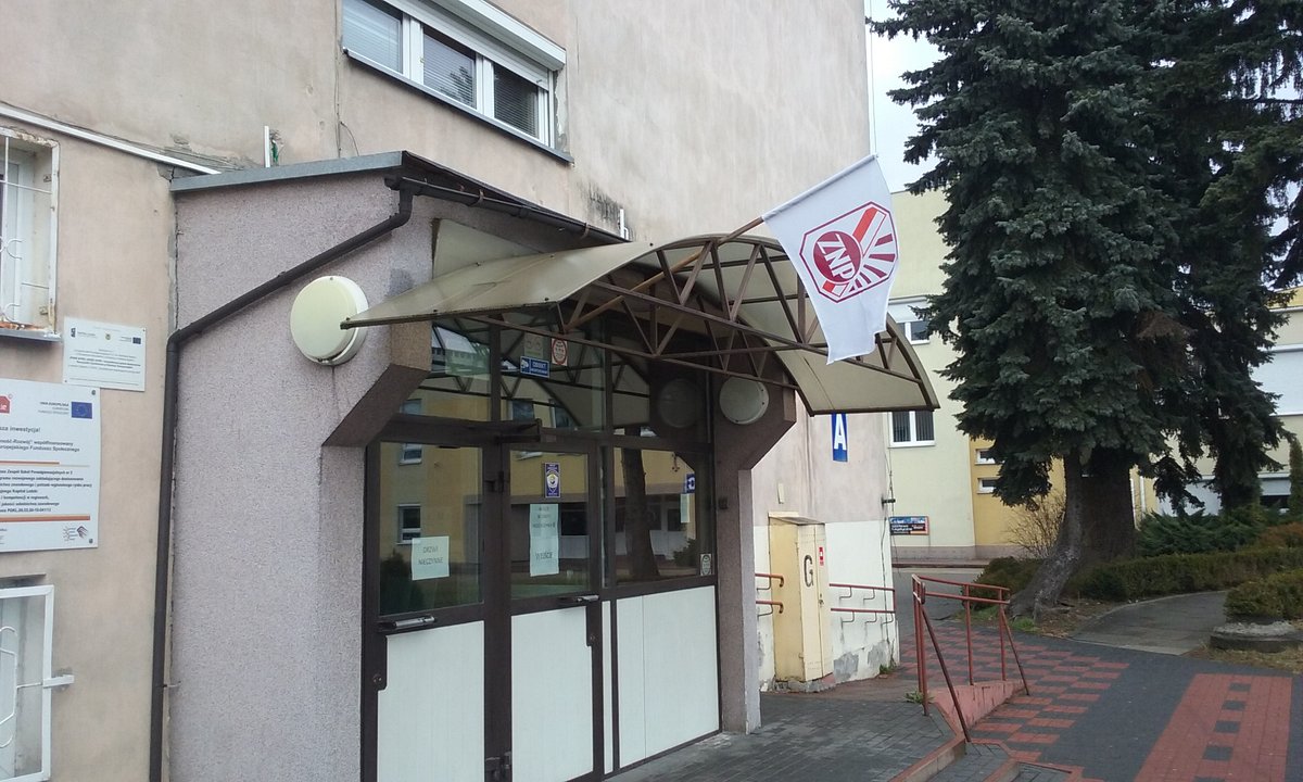 Flag of ZNP (Polish Teachers' Union) in front of the entrance to ZSP2 (Gastronomik) building in Tomaszów Mazowiecki, Łódź Voivodeship