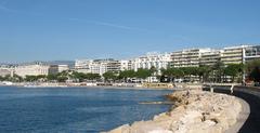 Cannes La Croisette promenade by the sea with palm trees and luxury buildings