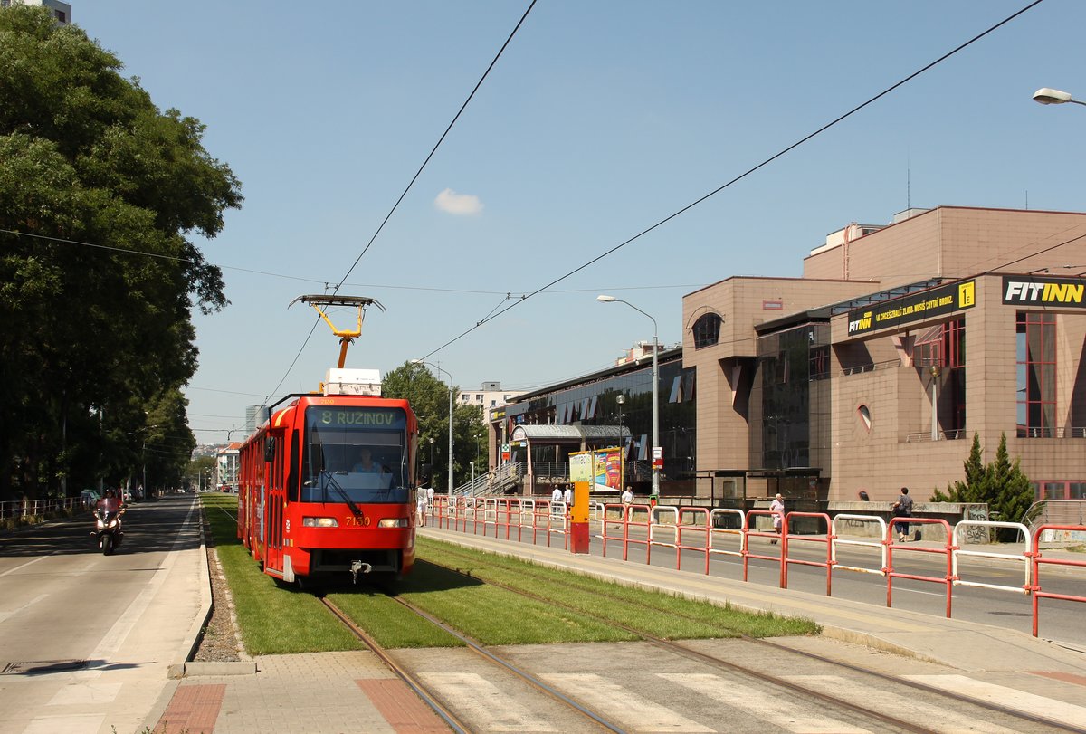 Tram 7130 on Line 8 towards Astronomická on grass tracks at Záhradnícka stop near Slovanet