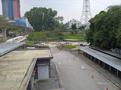 View of parking area at Muhibbah LRT Station in Kuala Lumpur with parked cars and surrounding greenery
