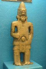 Replica of Huasteca Culture masculine figure statue with conical cap and skull, located at Metro Bellas Artes, Mexico City
