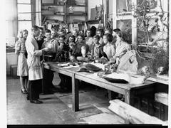 Man in lab coat showing stuffed birds and animal specimens to children at South Australian Museum