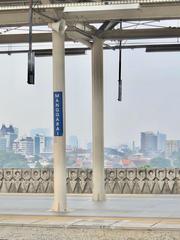 Manggarai Station in the evening with trains and buildings illuminated