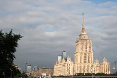 Hotel Ukraina in Moscow at dusk with illuminated facade and surrounding cityscape