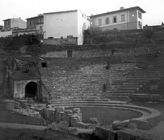 Ancient theater ruins with stone seating and landscape in the background