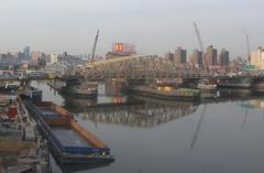 Willis Avenue Bridge reflecting over calm water on a sunny afternoon