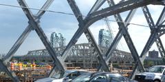 View through the truss of the old Willis Avenue Bridge at the new Willis Avenue Bridge with Triboro Bridge in the background on a sunny afternoon