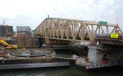 View northeast from Manhattan showing the new Willis Avenue Bridge and the empty bearing of the old rotating Willis Avenue Bridge on a partly cloudy late afternoon
