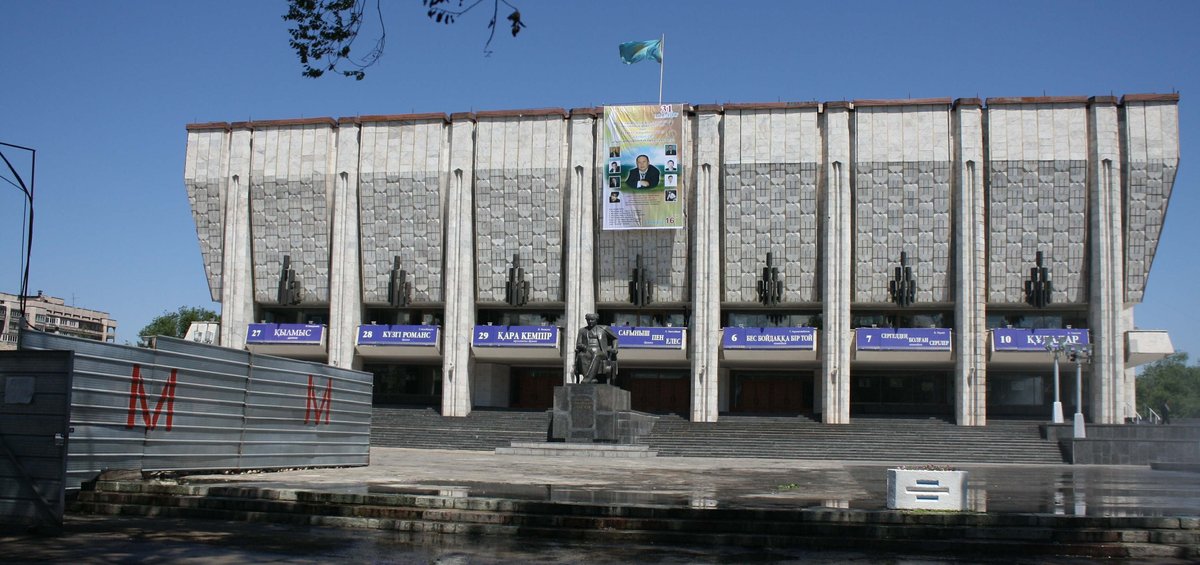 Kazakh Auezov Drama Theatre and Almaty Metro Station Tulpar under construction with red M-letter on left iron fence
