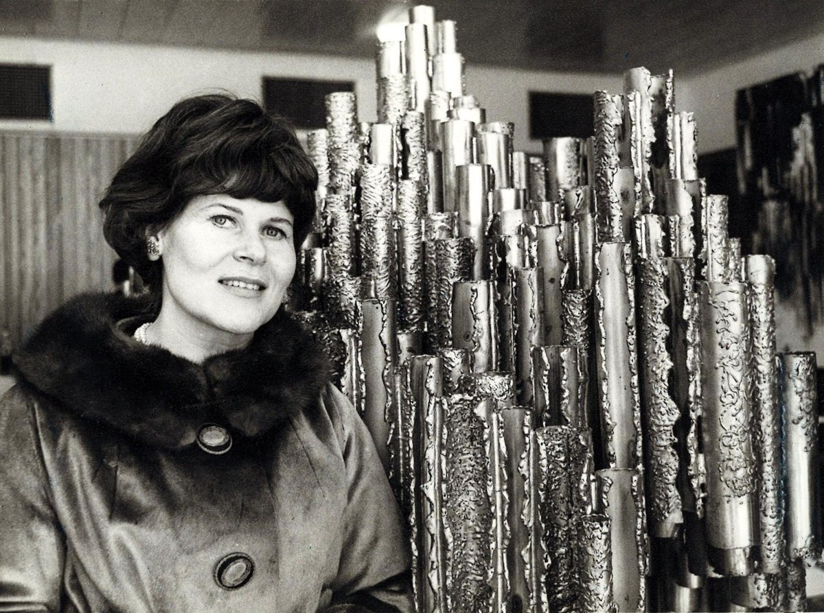 Portrait of Finnish sculptor Eila Hiltunen holding a miniature Sibelius Monument