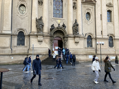 Photograph taken in Prague the day after the shooting, showing a street scene with people going about their day