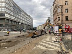 Street view of Od Vltavské k BioOku with buildings, tram tracks and parked cars on a cloudy day