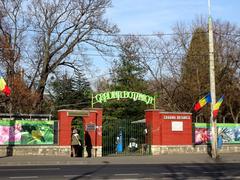 Main entrance of Bucharest Botanical Garden with ornate iron gate and green plants