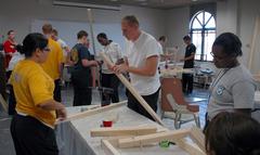 Navy Junior ROTC cadet ensigns assembling a wooden catapult during STEM seminar