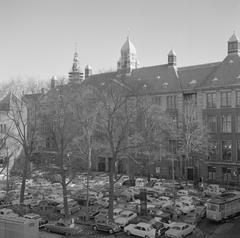 1965 Amsterdam stock exchange square filled with parked cars and city tram