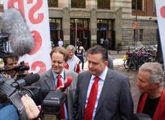 Dutch SP politicians Ewout Irrgang and Emile Roemer speaking to the press during an election campaign event at Beursplein, Amsterdam