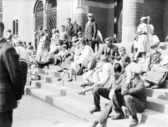 Vintage black and white photo of Het Beursplein in Amsterdam filled with people celebrating Koninginnedag, dated August 31, 1932