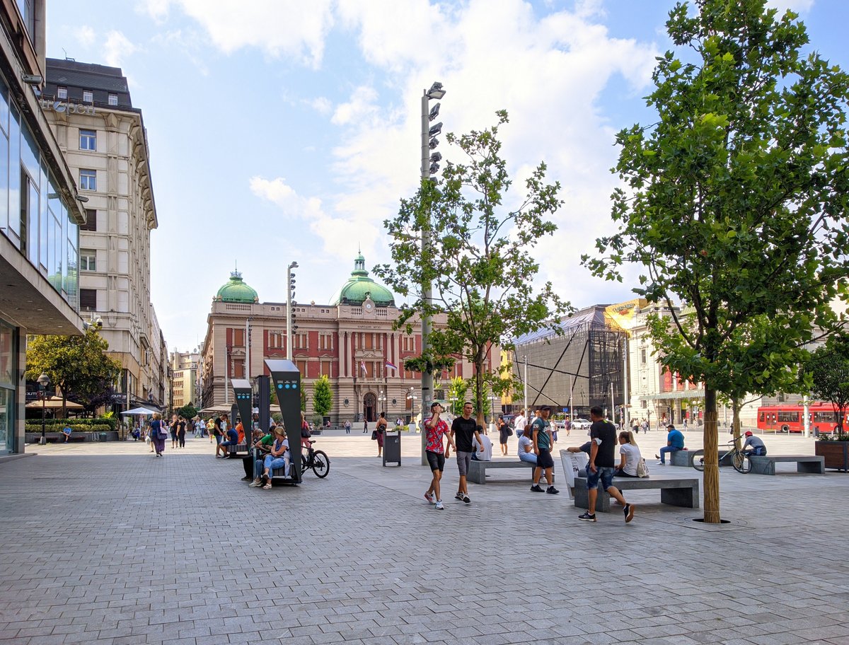 Belgrade Republic Square with tall monument and surrounding historic buildings under blue sky