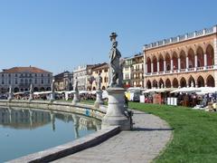 Market day at Prato della Valle in Padova, Italy with people, stalls and historic buildings